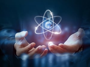 Atom rendering hovering over two hands.
