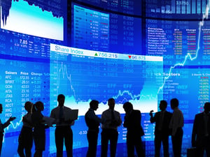 Business people with stocks tracking imagery in the background.